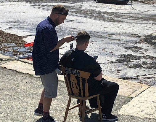 Bruno, cutting hair on the seaside in Porthleven, Cornwall
